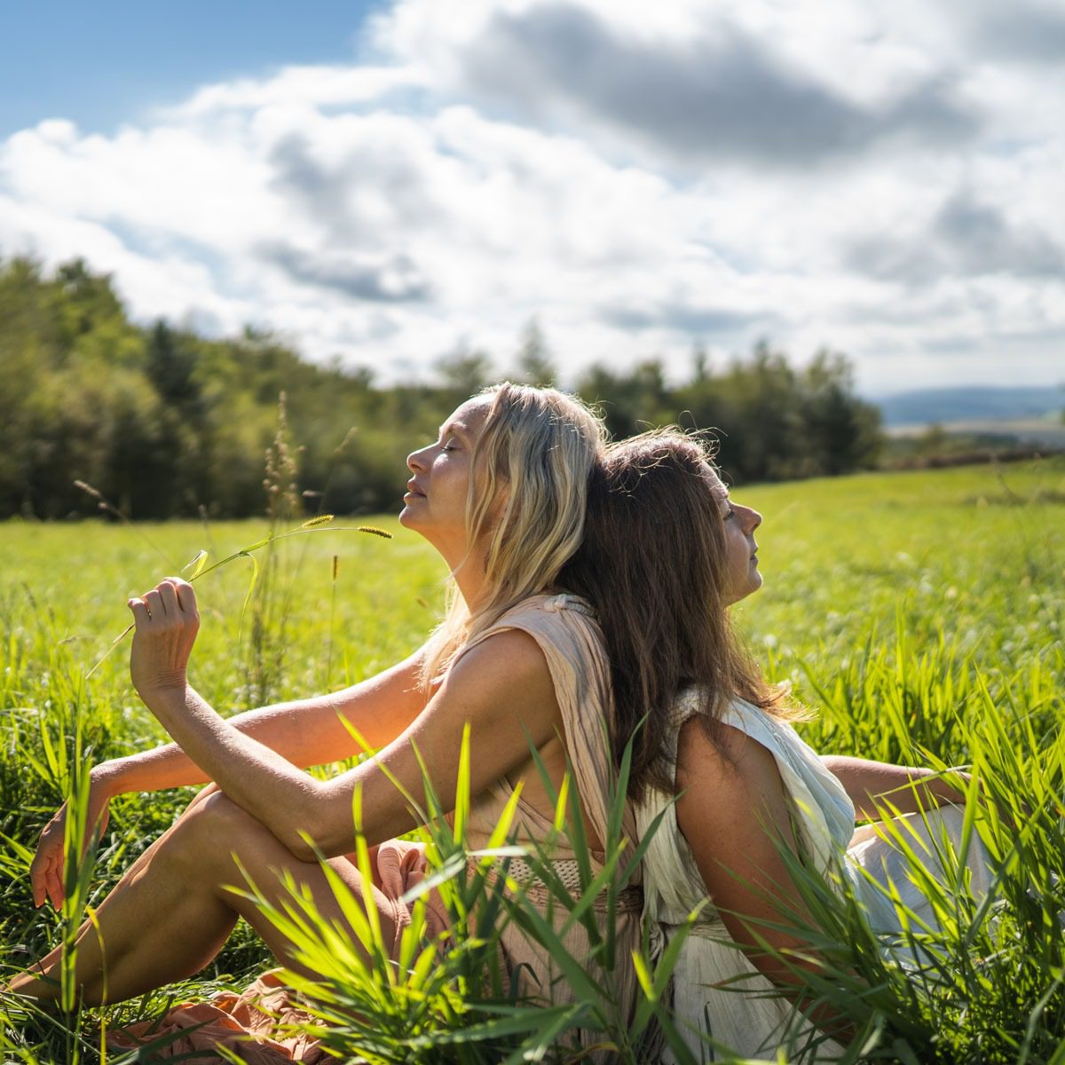 sisters on a meadow in long dresses
